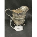 Hallmarked Silver (Irish): Helmet cream jug embossed with country scenes, with a C scroll handle,