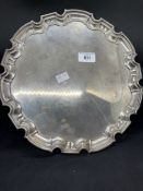 Hallmarked Silver: Salver with scalloped border on three scrolled leaf feat. 12ins. Weight 29.12oz.