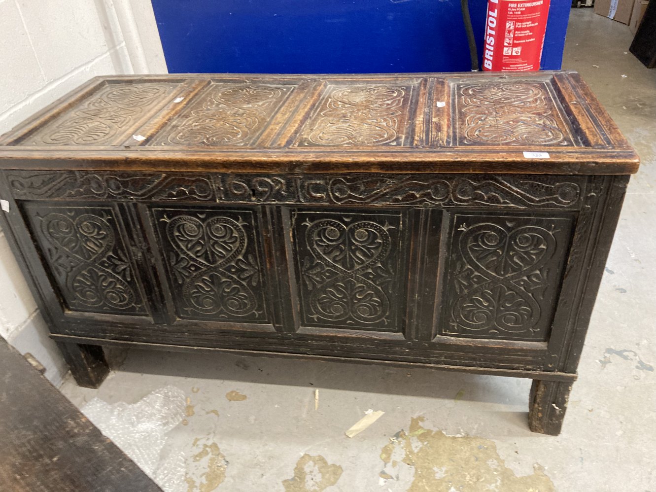 Antique oak coffer with four panelled top and front with carved panels. Carved frieze with date 1692