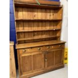 19th cent. Pine dresser the top with moulded cornice and three graduated shelves. The base with