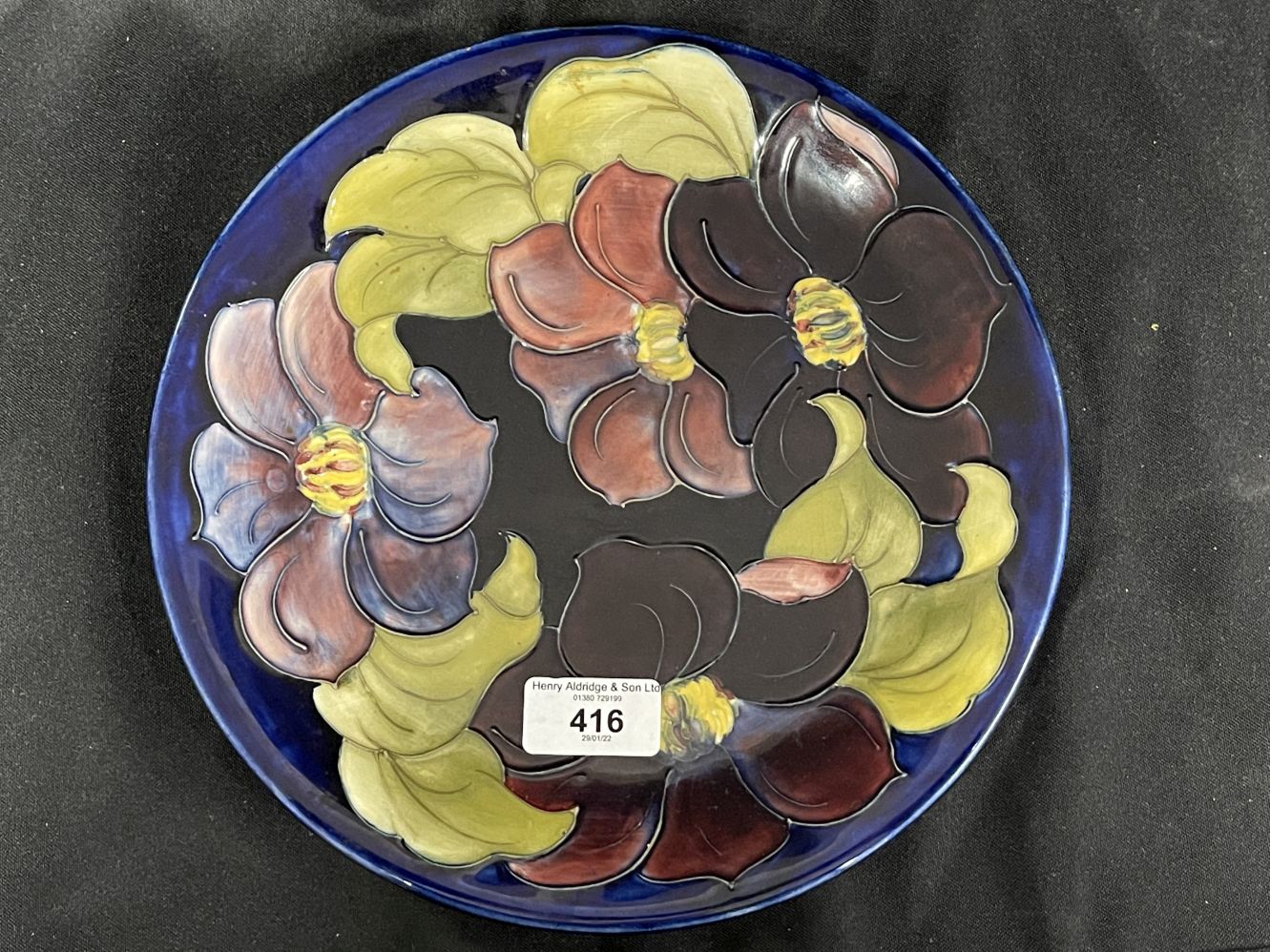 20th cent. Ceramics: Moorcroft plate, 'Anemone', dark blue background, deep purple and pink anemone.