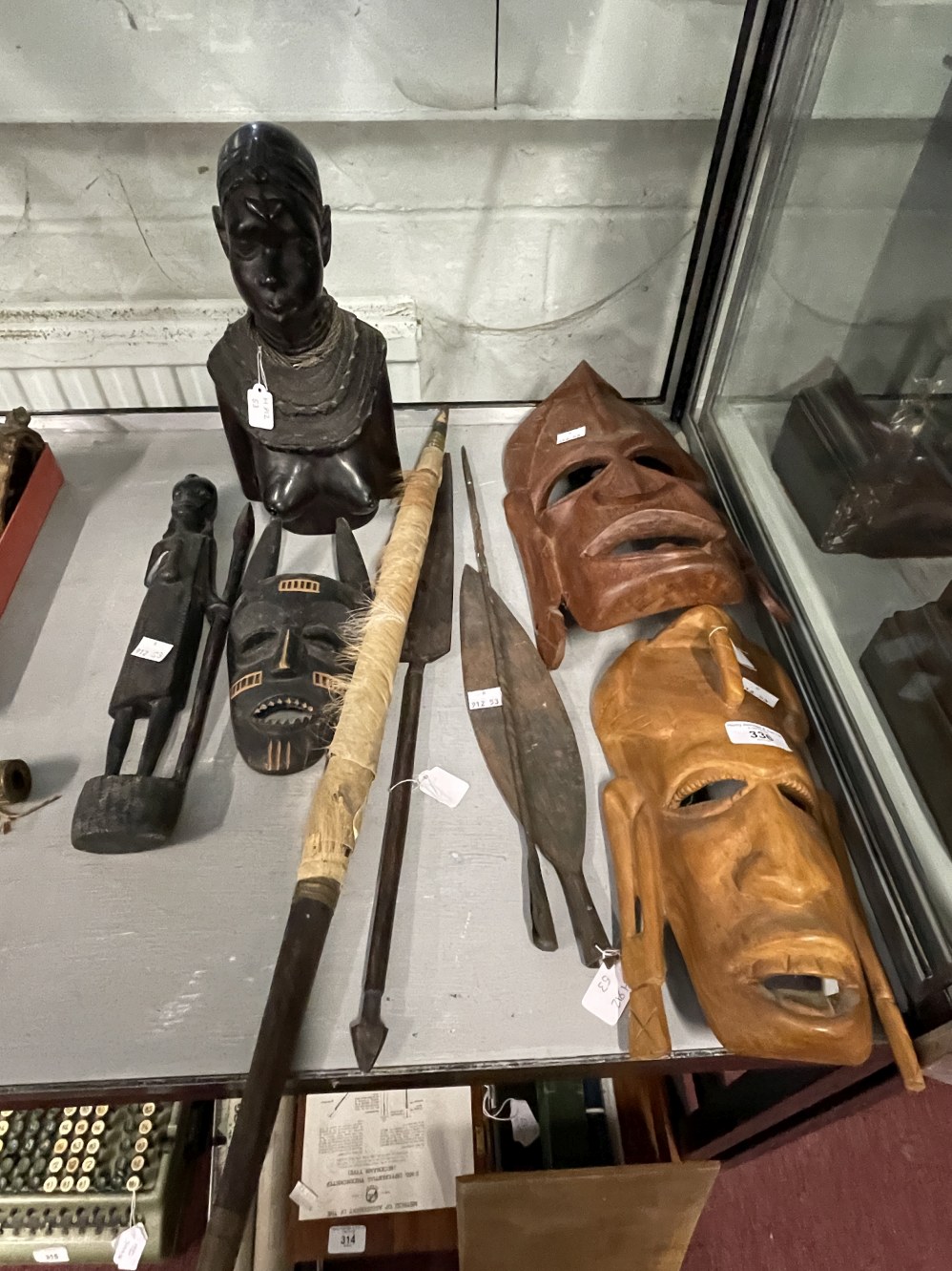 Tribal Artefacts: Includes ebony female bust, three wooden masks, a figure and four weapons.