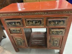 Chinese: 20th cent. Red lacquer kneehole desk with black and gilt chinoiserie decoration. 39ins. x