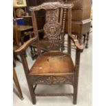 20th cent. Oak chair with heavily carved central back depicting a face with leaf decoration to top