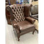 20th cent. Thomas Lloyd brown leather wing armchair with Chesterfield style back.