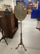 19th cent. Mahogany pole screen the oval embroidered panel in a glazed and moulded surround on a