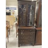 Late 19th cent. Slender mahogany glazed bookcase over four drawer chest, on bracket supports. 30ins.