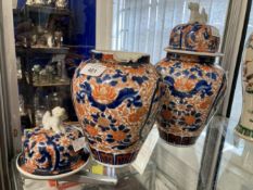 19th cent. Japanese Imari lidded vases, a pair. One vase damaged, the lids with lion dog finials.