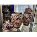 19th cent. Japanese Imari lidded vases, a pair. One vase damaged, the lids with lion dog finials.