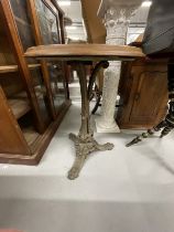 20th cent. Cast iron table with circular teak top and a black and gilt gypsy type table with