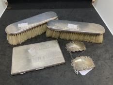 Hallmarked Silver: Cigarette case, two wine labels and two silver back brushes. 7oz.