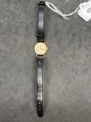 Watches: 9ct yellow gold Omega ladies watch. Champagne coloured dial on black strap.