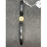 Watches: 9ct yellow gold Omega ladies watch. Champagne coloured dial on black strap.