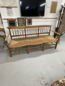20th cent. Elm Shaker style spindle back three seater settee, rattan seat and curving arms on
