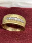 18ct gold band set with seven brilliant cut diamonds, estimated weight of (7) 0.15ct. Weight 5.9g.