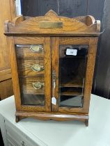 20th cent. Oak smokers companion glazed door, fitted interior of three drawers, pipe rack, storage