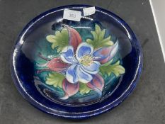 William Moorcroft 'Orchid' deep dish c1930-40 decorated with a blossoming orchid on a blue ground,
