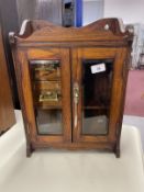 20th cent. Oak smokers companion glazed doors, fitted interior of two drawers, pipe rack, storage