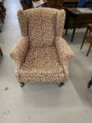 19th cent. Wingback armchair on turned castored supports, re-upholstered.