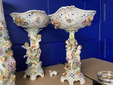 Early 20th cent. Dresden porcelain table centrepieces each with cherubs climbing amongst flowers,