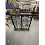 20th cent. Chinoiserie style ebonised display cabinet, four glazed sides above a fretwork base.