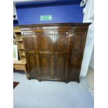 1920s mahogany break front wardrobe with castellated pelmet over four doors decorated with applied