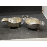 Hallmarked Silver: Pair of sauce boats with scalloped border C scroll handles and three claw feet,