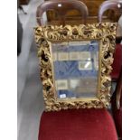 Late 19th cent. Small Florentine style carved and gilt mirror with bevelled plate. 22ins. x 18ins.
