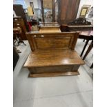 20th cent. Oak low back settle with back panel with carved flower lift up seat above a moulded base.