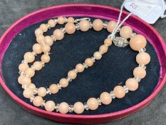 Liberty & Co. Jewellery: Necklace of forty-three graduated pink coral beads interspersed with