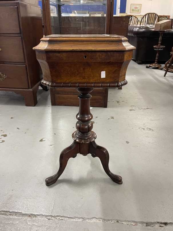 Victorian walnut work table the hinged top with canted corners on a turned column and tripod base.