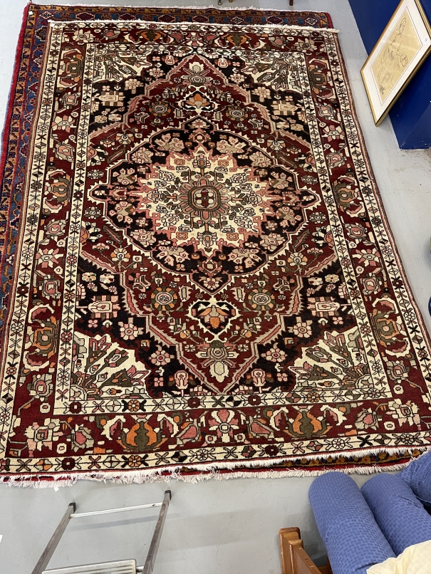 Carpets: Persian carpet with geometric and floral motifs on a predominantly maroon ground. 114ins. x