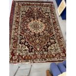 Carpets: Persian carpet with geometric and floral motifs on a predominantly maroon ground. 114ins. x
