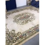 Carpets & Rugs: British made ivory ground woolen carpet with central floral decoration with a