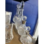 Glass: Two cut glass bottles with silver tops and glass stoppers and two glass decanters.