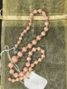 Liberty & Co. Jewellery: Necklace of forty-three graduated pink coral beads interspersed with