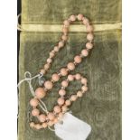 Liberty & Co. Jewellery: Necklace of forty-three graduated pink coral beads interspersed with