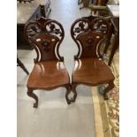 19th cent. Cuban mahogany hall chairs, cabriole legs with pierced scroll shaped backs, a pair.