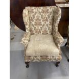 19th cent. Upholstered high wing back chair, front pad feet sloping rear supports. Height 43ins.