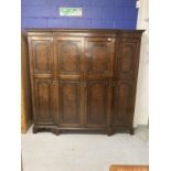 1920s mahogany break front wardrobe with castellated pelmet over four doors decorated with applied