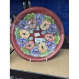 20th cent. Ceramics: Moorcroft plate in the Pansy pattern, on mauve ground. Appears to be a