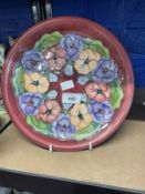 20th cent. Ceramics: Moorcroft plate in the Pansy pattern, on mauve ground. Appears to be a