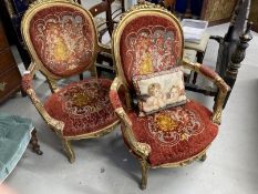 20th cent. French gilt armchairs, upholstered backs and seats, open arms, a pair. Height 40ins.