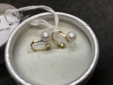 Jewellery: Yellow metal pair of single 6mm cultured pearl studs with screw fittings, stamped 14K,