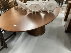 Quatropi walnut dining table the oval top with inset circular central glass panel supported by a