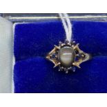 Jewellery: Yellow metal ring in the form of an oval cluster centre stone being an oval cut star