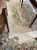 Carpets & Rugs: British made ivory ground woolen carpet with central floral decoration with a