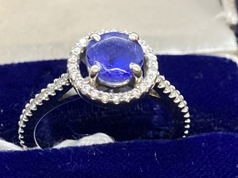 Jewellery: White metal ring in the form of a halo centre set with a circular cut tanzanite,