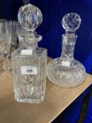 Early 20th cent. Cut glass decanters, one onion shaped, the other decorated with floral images. (2)