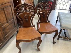 19th cent. Cuban mahogany hall chairs, cabriole legs with pierced scroll shaped backs, a pair.